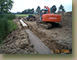 Setting-the-first-perch-of-stone-for-the-retaining-wall-for-hole-1